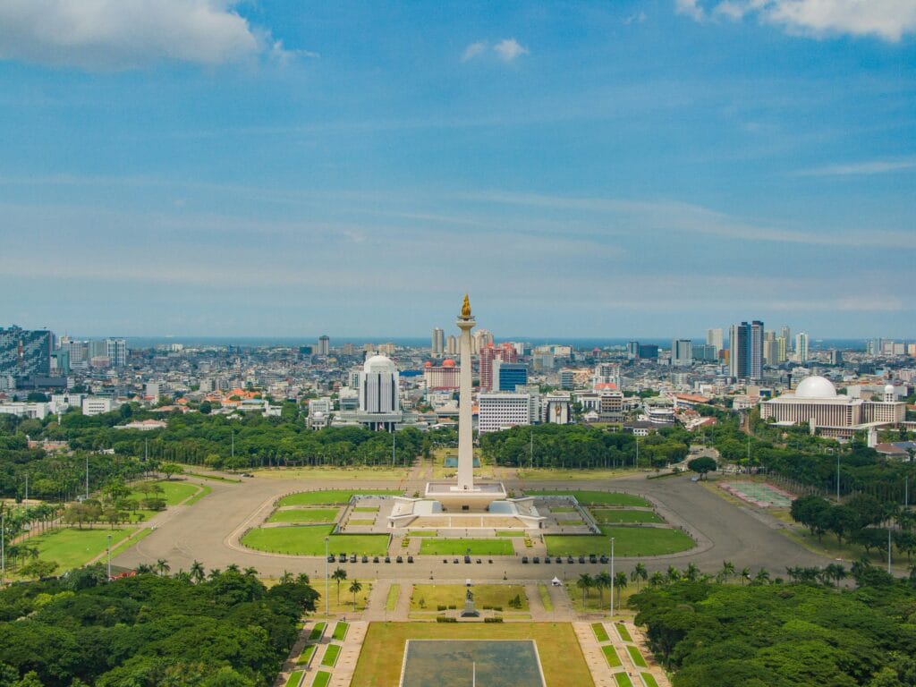 The National Monument (Monas) towering over the green parklands of Merdeka Square in Jakarta, Indonesia.